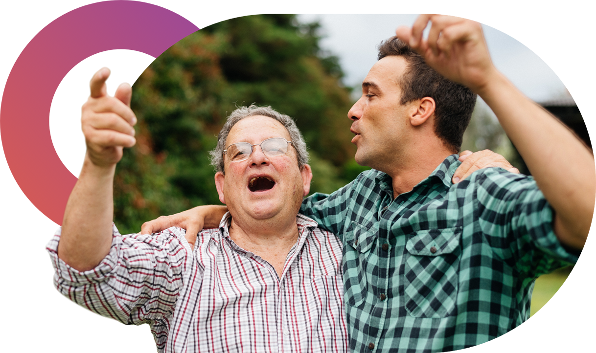 A care worker and client sharing a laugh outdoors